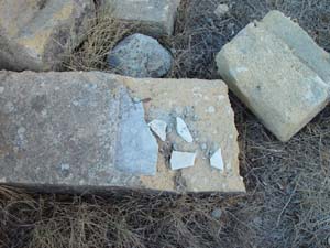 Broken and discarded gravestone